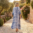 FJØRNA boho printed maxi dress with loose fit and V-neck, featuring vibrant floral patterns and flowing fabric for a relaxed style.