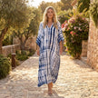 FJØRNA boho printed maxi dress with loose fit and V-neck, featuring vibrant patterns and flowing fabric.