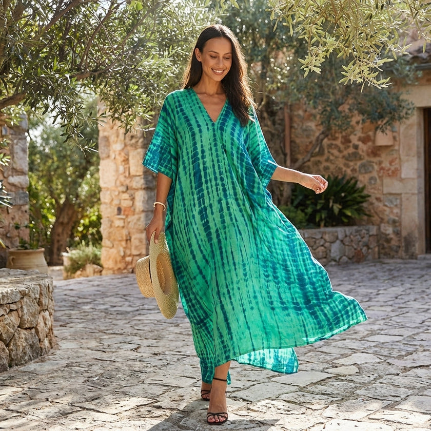FJØRNA boho printed maxi dress with loose fit and V-neck, featuring vibrant patterns and flowing fabric.
