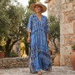 FJØRNA boho printed maxi dress with loose fit and V-neck, featuring colorful floral patterns and flowing fabric.