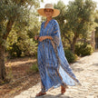 FJØRNA boho printed maxi dress with loose fit and V-neck, featuring colorful patterns and flowing fabric.
