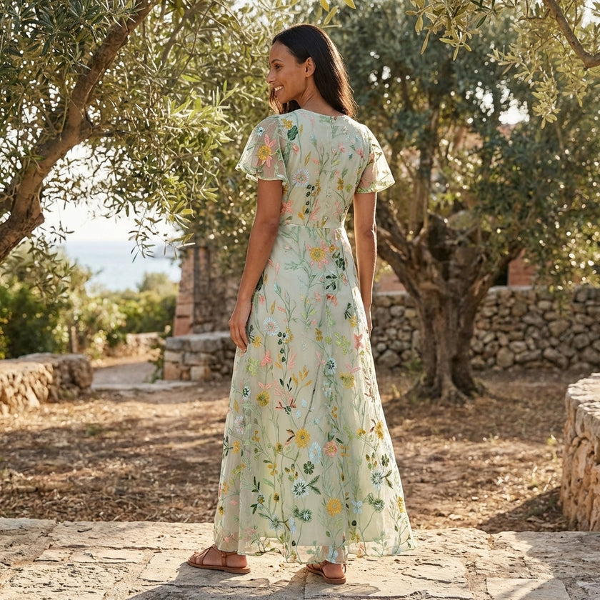 FJØRNA floral chiffon maxi dress with short sleeves and V-neck, flowing and elegant for summer or special occasions.