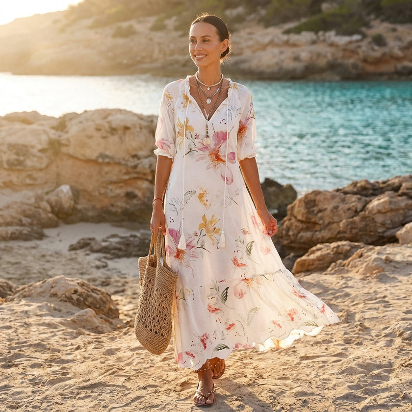 FJØRNA floral V-neck maxi dress with short sleeves, flowing fit, and vibrant flower print, perfect for warm weather occasions.