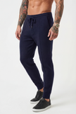FJØRNA navy merino wool trousers shown hanging, featuring a tailored fit and smooth texture for casual and professional wear.