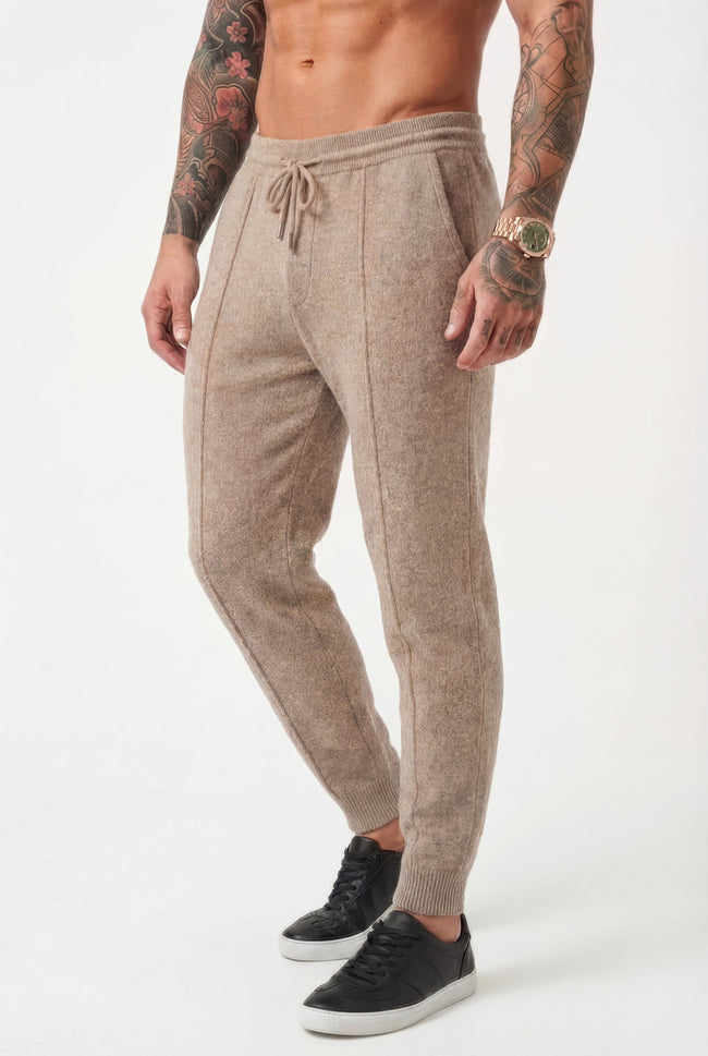 Men’s beige Merino wool trousers by FJØRNA, slim-fit pants with a smooth wool texture and tailored design.