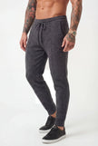 Dark grey FJØRNA Merino Wool Trousers with a tailored fit, shown on a model, highlighting the fabric texture and sleek design.