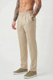 FJØRNA tailored cream trousers with a slim fit, featuring classic design and smooth fabric, shown on a model.