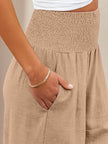 FJØRNA women's linen summer trousers with high waist, wide-leg design, and drawstring for a relaxed, breathable fit.