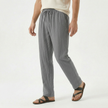 Men's linen drawstring trousers by FJØRNA, featuring lightweight fabric, relaxed fit, and adjustable waist in a neutral color.