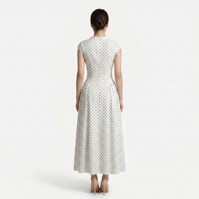 FJØRNA women's polka dot maxi dress with round neckline and A-line silhouette, flowing fabric and knee-length skirt.
