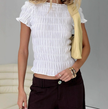 White plaid ruffle-detail women's blouse from FJØRNA featuring a stylish top with ruffles and a classic plaid pattern.