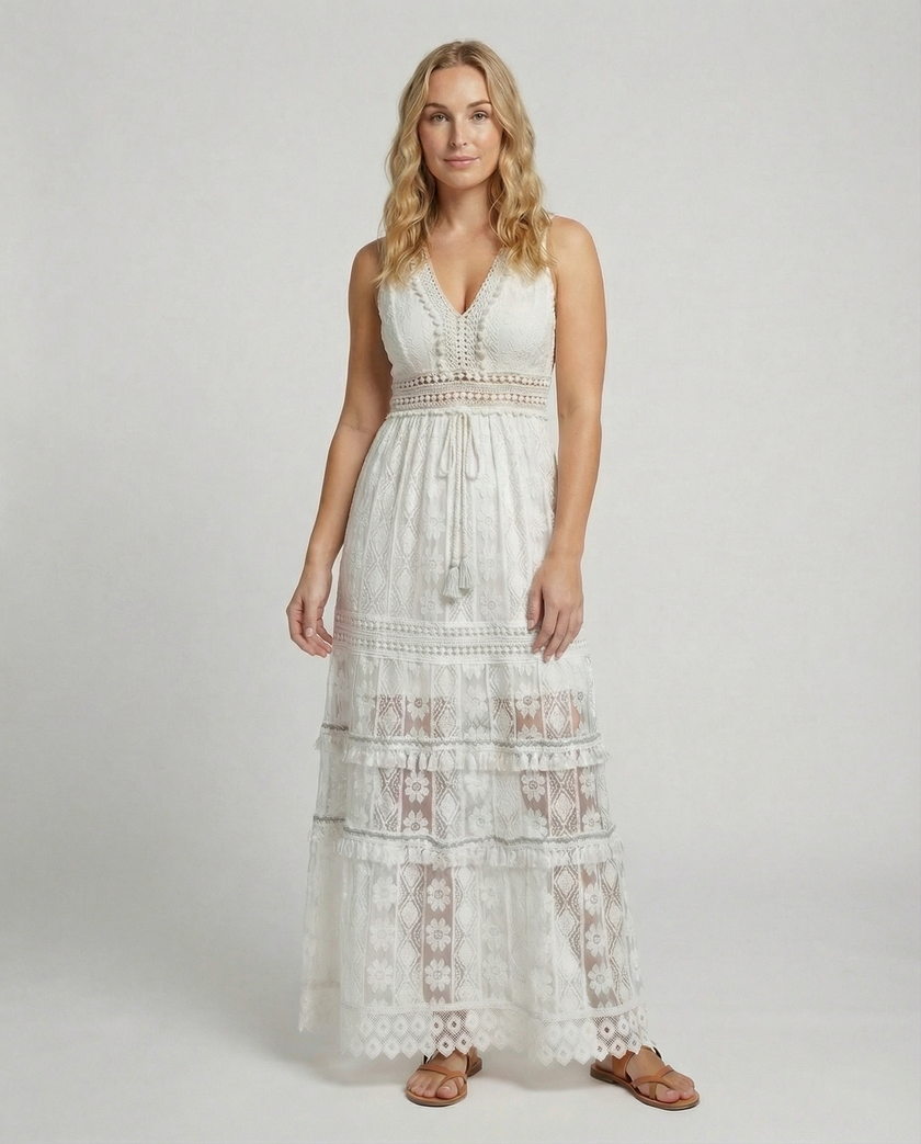 FJØRNA bohemian lace maxi dress with tiered skirt and tassel waist, featuring intricate lace details and flowing fabric.