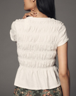FJØRNA women's linen peplum blouse with long sleeves and V-neck, featuring a lightweight, breathable fabric and stylish design.