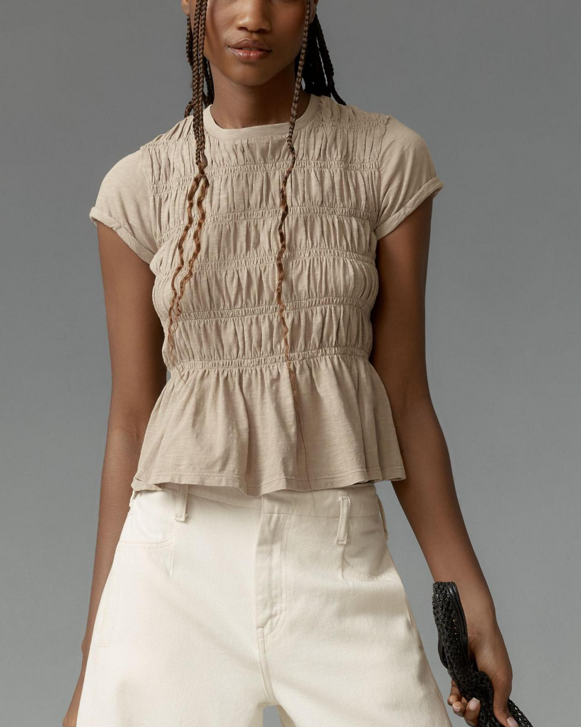 FJØRNA women's linen peplum blouse with long sleeves and a relaxed fit, displayed on a hanger.