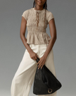 FJØRNA women's linen top with ruffle detail, lightweight and stylish for casual wear, shown in soft natural fabric.
