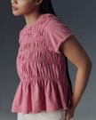 FJØRNA women's linen top with ruffle detail, lightweight and stylish, showcasing the textured fabric and feminine design.