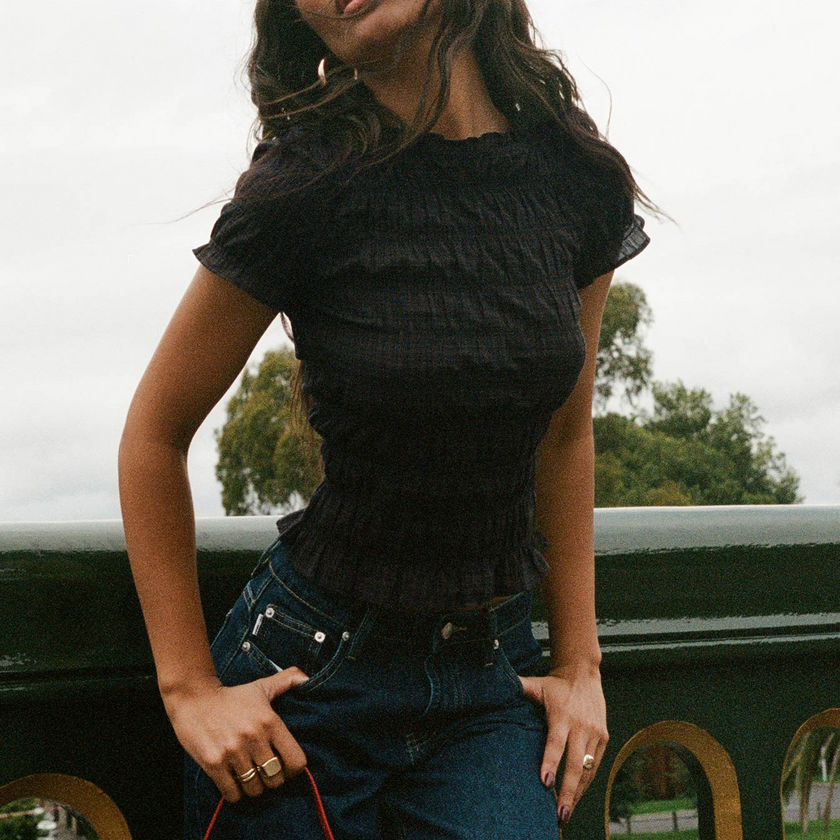 FJØRNA women's plaid top with ruffle detail, featuring a stylish, lightweight design and classic plaid pattern.