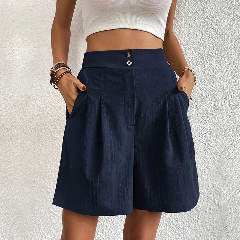 FJØRNA women's lightweight summer shorts with high waist and wide-leg pleated design, shown in neutral fabric on a model.