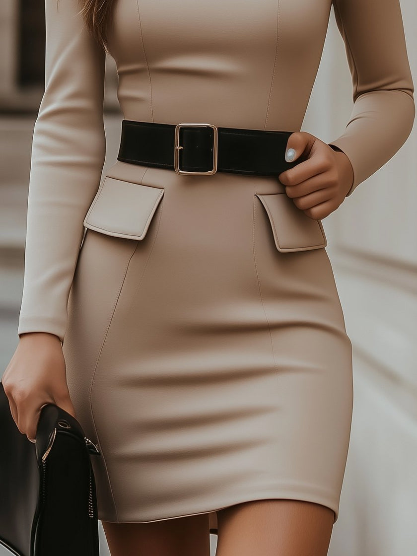 Beige turtleneck bodycon dress by FJØRNA with black belt accent, form-fitting design, and elegant silhouette.