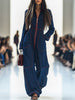 Dark blue FJØRNA denim jumpsuit with wide-leg pants, topstitch detailing, and long sleeves, styled for a casual look.