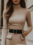 Beige turtleneck bodycon dress by FJØRNA featuring a black belt accent, fitted silhouette, and elegant design.
