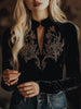 Black velvet V-neck long sleeve top with embroidered details from FJØRNA, shown on a model.