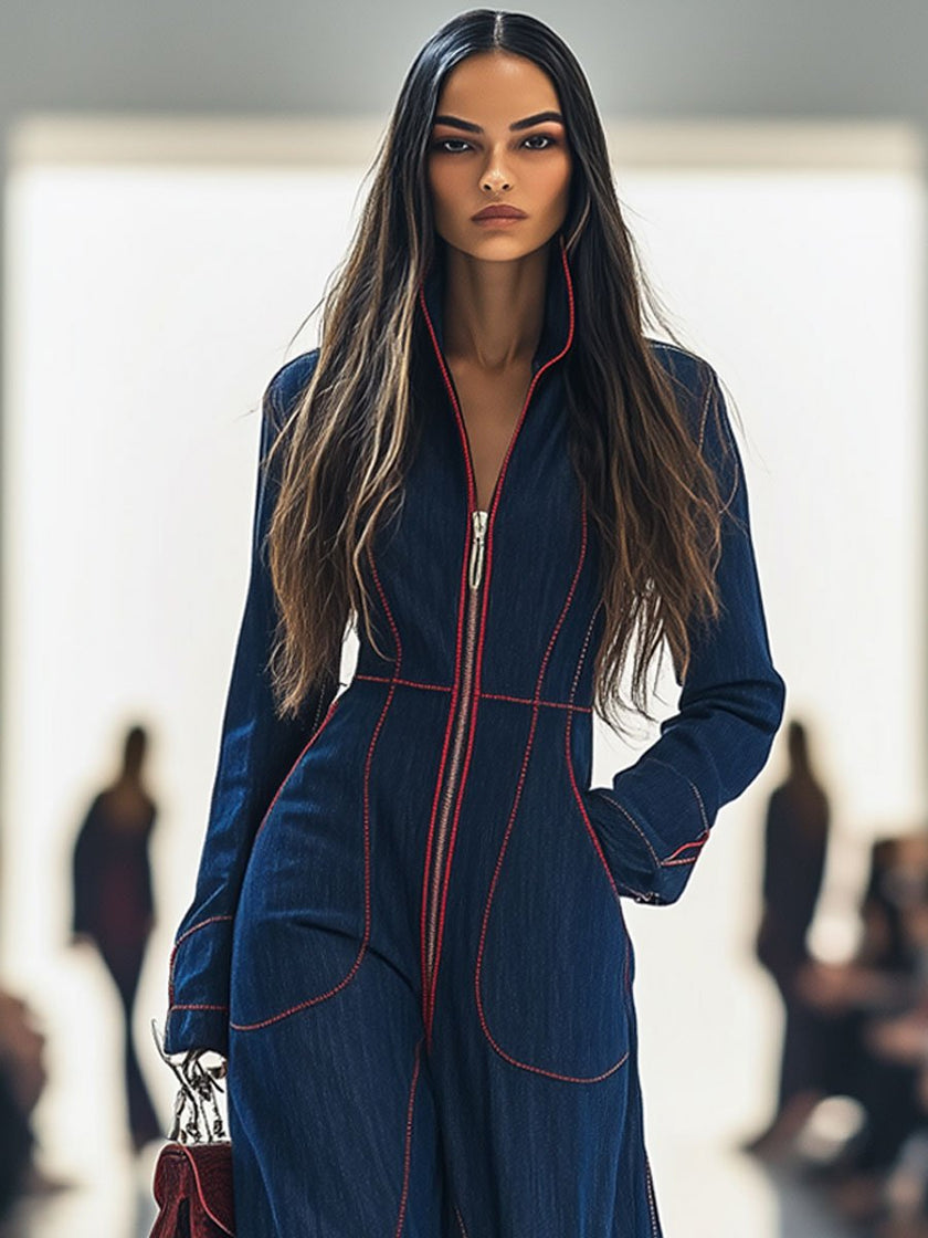 Dark blue FJØRNA denim jumpsuit with wide-leg pants and long sleeves, featuring topstitch detailing and a fitted waist.