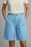 FJØRNA Juniper women's elastic waist relaxed fit shorts, beige color, soft fabric, casual style, front and side view.