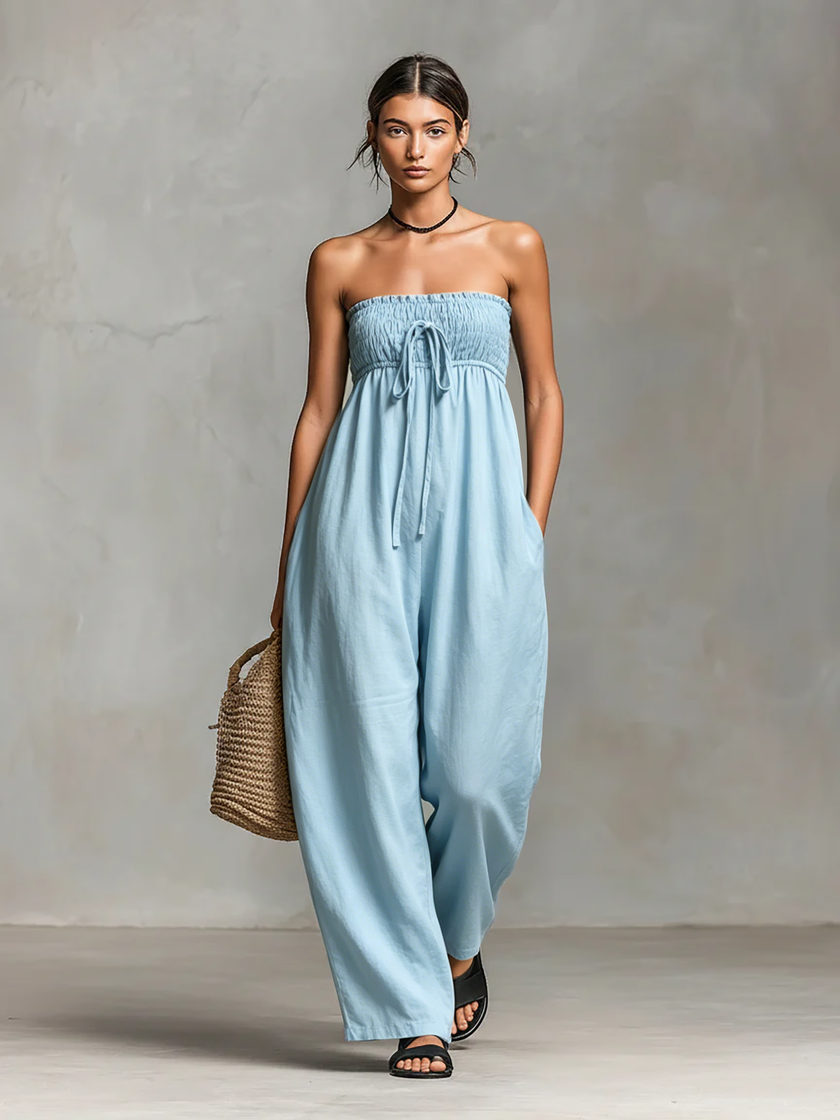 FJØRNA linen blend strapless women's jumpsuit with loose fit and tie closure, displayed on a hanger against a plain background.