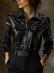 Black embossed FJØRNA women's sleeveless shirt with crocodile texture and glossy finish, showcasing a fitted and stylish top.