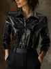Black embossed FJØRNA women's sleeveless shirt with crocodile texture and glossy finish, showcasing a fitted and stylish top.