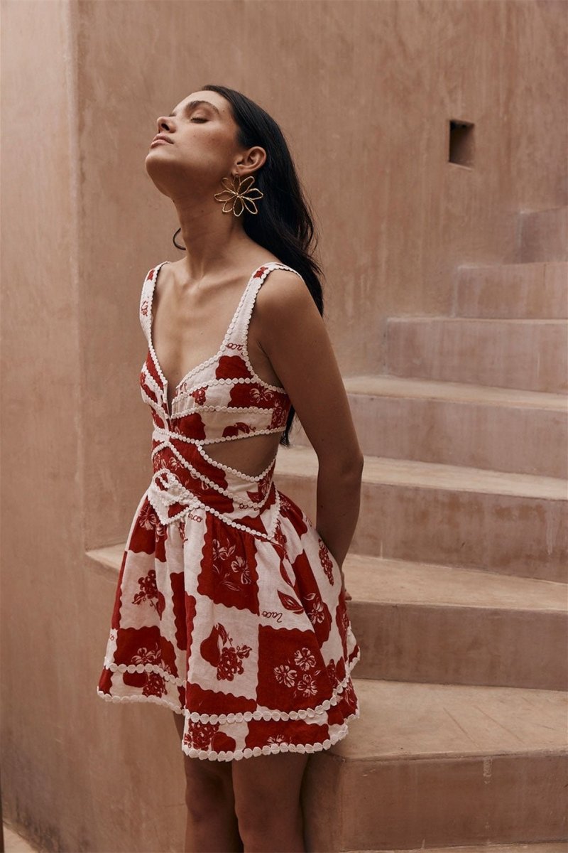 FJØRNA Leila printed cut-out mini dress in red with floral pattern, featuring a stylish mini length and cut-out details.