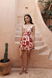 FJØRNA Leila printed cut-out mini dress in red with floral pattern, featuring a stylish cut-out detail and short sleeves.
