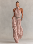 FJØRNA blush pleated women's jumpsuit with halter neck, ruched waist, and wide-leg pants, shown in the product image.