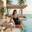 FJØRNA women's summer one-piece swimsuit with v-neck, wrap design, and ruched detail, perfect for beach and poolside wear.