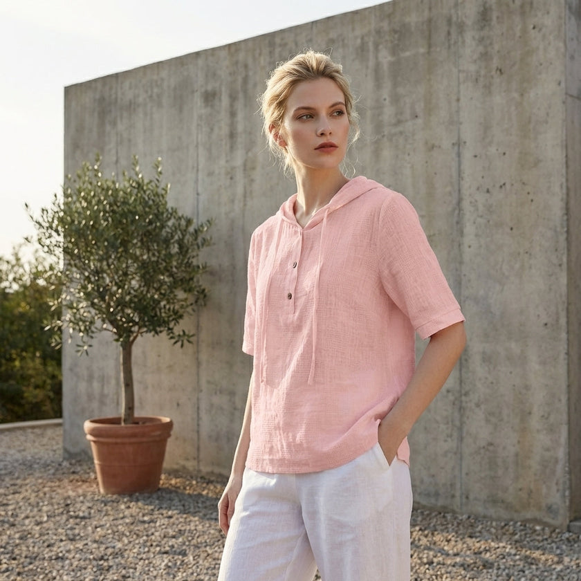 FJØRNA women's summer blouse with short sleeves and linen fabric, styled casually with a relaxed fit in a bright outdoor setting.