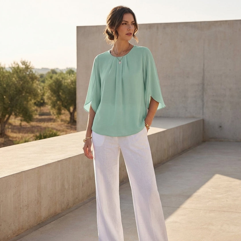 FJØRNA women's summer blouse with pleated design, casual style, worn as a top in a lifestyle setting.