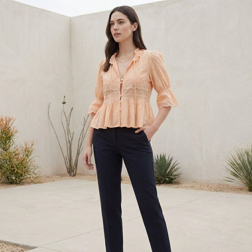 FJØRNA women's summer blouse with V-neck, puff sleeves, and lace details, styled in a casual outdoor setting.