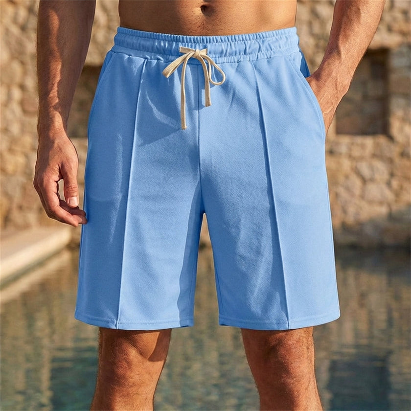 Men's light blue relaxed knee-length tailored shorts by FJØRNA with adjustable waist and stylish seam details.
