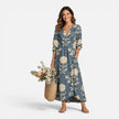 FJØRNA women's floral maxi dress made of linen, featuring a playful summer design with vibrant floral patterns.