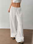 FJØRNA Mirabelle women's wide-leg drawstring casual pants, light fabric, relaxed fit, shown on a model with hands in pockets.