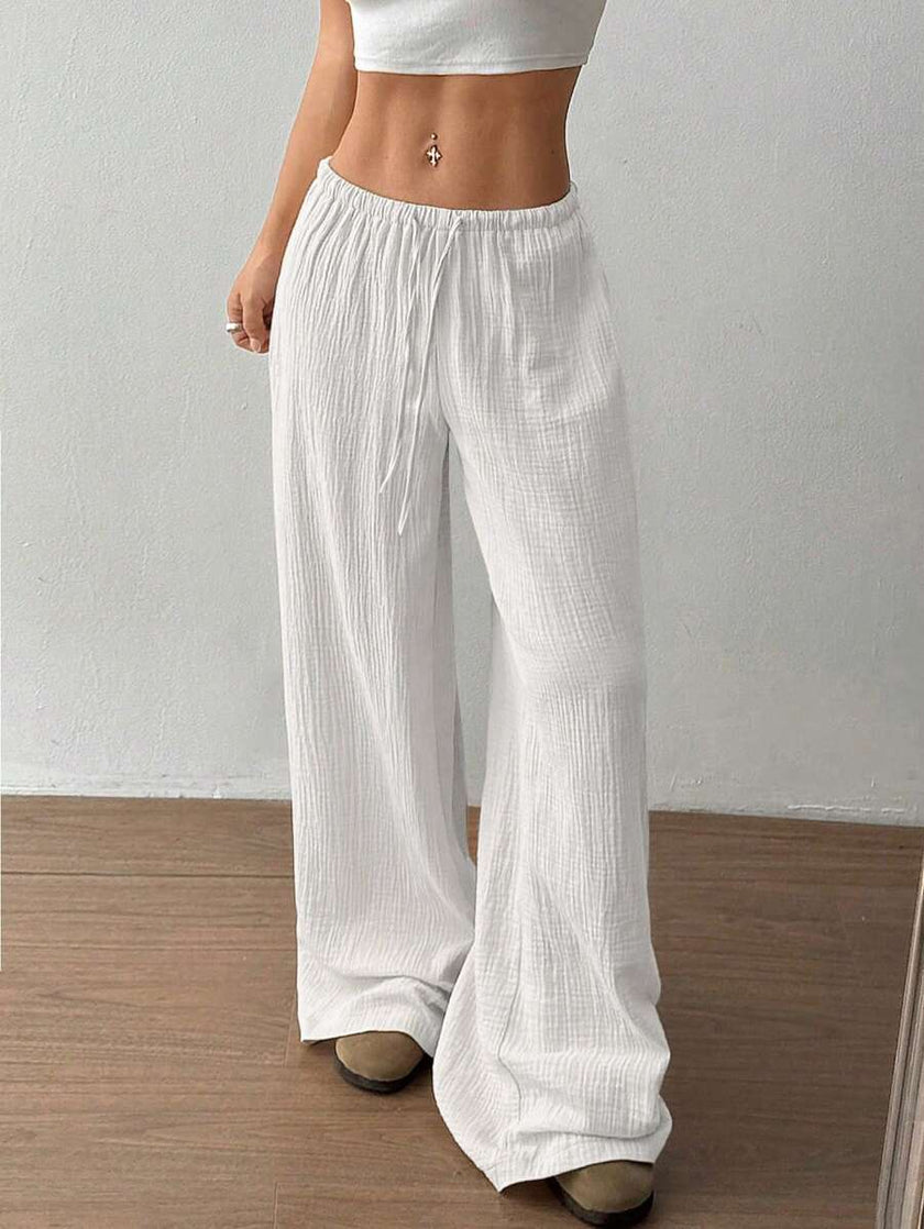 FJØRNA Mirabelle women's wide-leg drawstring casual pants, light fabric, relaxed fit, shown on a model with hands in pockets.