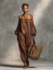 Full-body shot of a female model walking in a linen blend strapless jumpsuit with long sleeves and wide-leg pants by FJØRNA.
