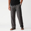 Men's FJØRNA breathable linen trousers laid flat, showcasing lightweight, comfortable design and natural fabric texture.
