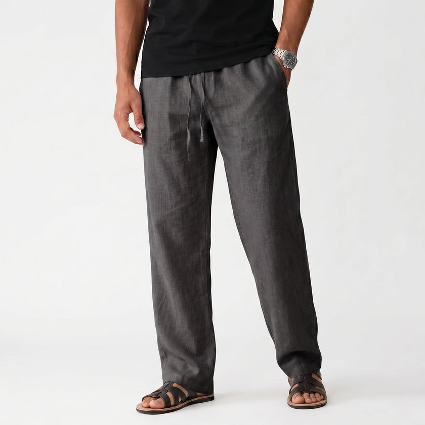 Men's FJØRNA breathable linen trousers laid flat, showcasing lightweight, comfortable design and natural fabric texture.