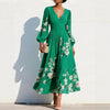 FJØRNA floral print long-sleeved V-neck pleated dress featuring elegant floral design and flowing fabric.