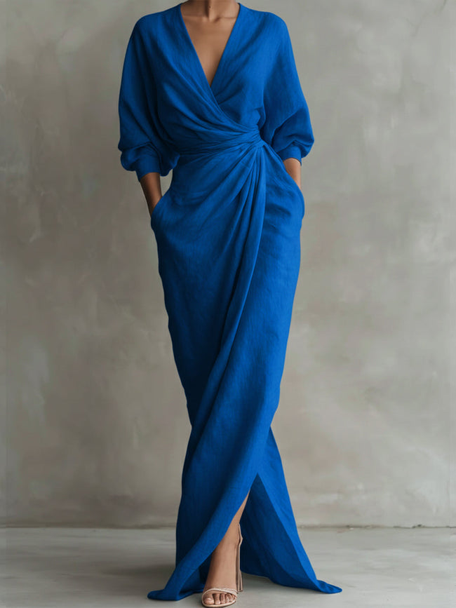 FJØRNA white V-neck wrap waist long sleeve maxi dress displayed on a hanger, showcasing its elegant design and flowing fabric.