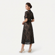 Women's elegant lace midi dress by FJØRNA featuring a high neck, refined cutwork detail, and a sleek silhouette.