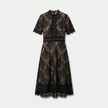 Women's elegant lace midi dress by FJØRNA featuring a high neck, refined cutwork detail, and a sophisticated silhouette.