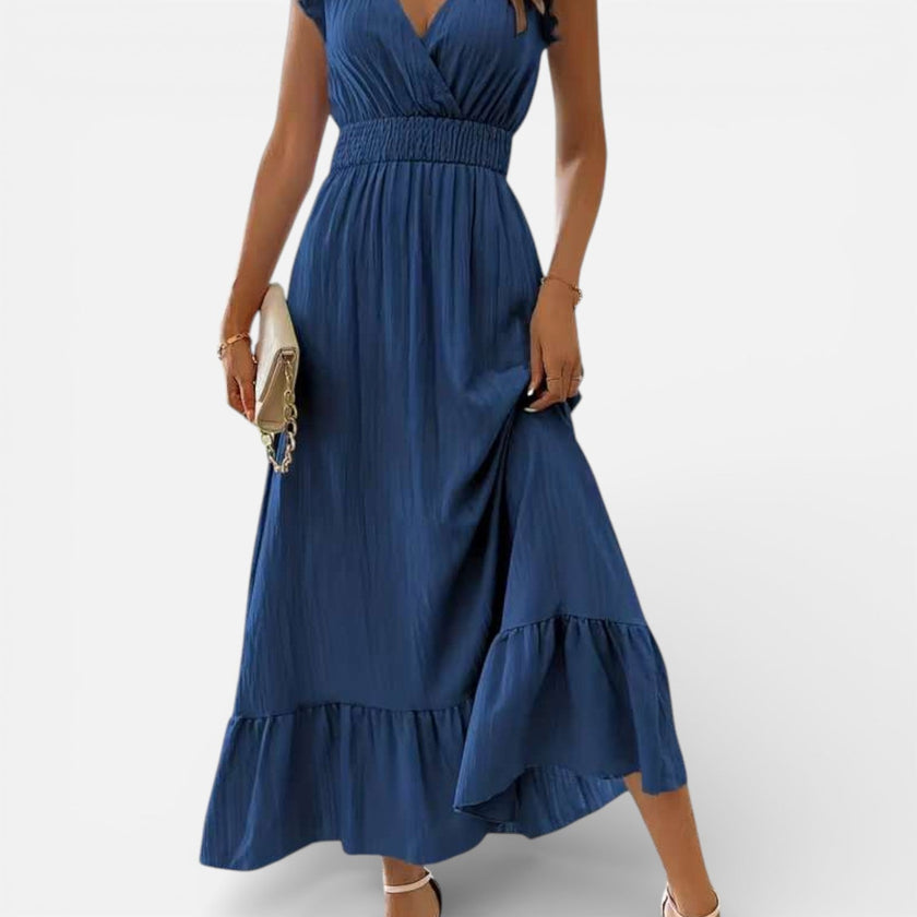 Women's sleeveless maxi dress by FJØRNA featuring a flowy fit and timeless style, shown hanging on a hanger.